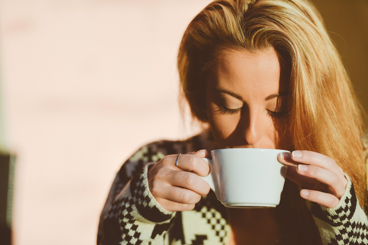 Tazza di caffè fumante su un tavolo, simbolo di energia e relax contro stress e fatica.