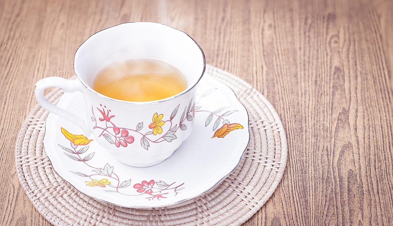 Tazza di tè verde fumante su un tavolo, simbolo di benessere e perdita di peso.