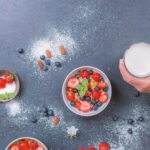 Varie bottiglie di latte vegetale su un tavolo, pronte per essere utilizzate in dolci.