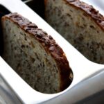 Fette biscottate integrali su un tavolo con frutta fresca e marmellata, simbolo di una colazione sana.