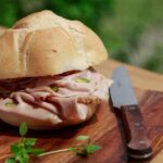 Fette di mortadella su un tagliere, evidenziando i valori nutrizionali e le porzioni consigliate.