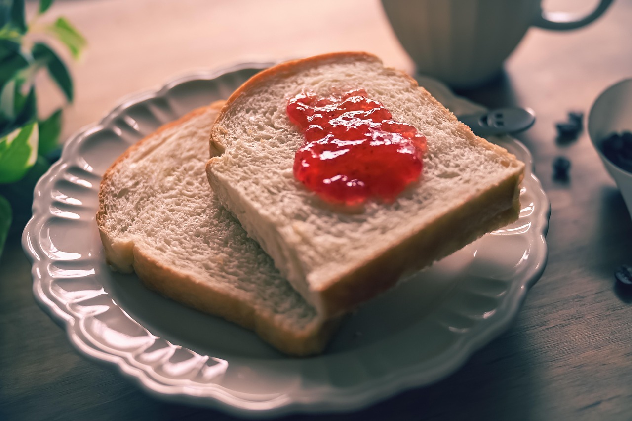 Immagine di una fetta di pane su un tavolo, con un misuratore di glicemia e un piatto di cibo sano accanto.