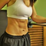 Persona che cammina su un sentiero, simbolo di esercizio per ottenere la pancia piatta.