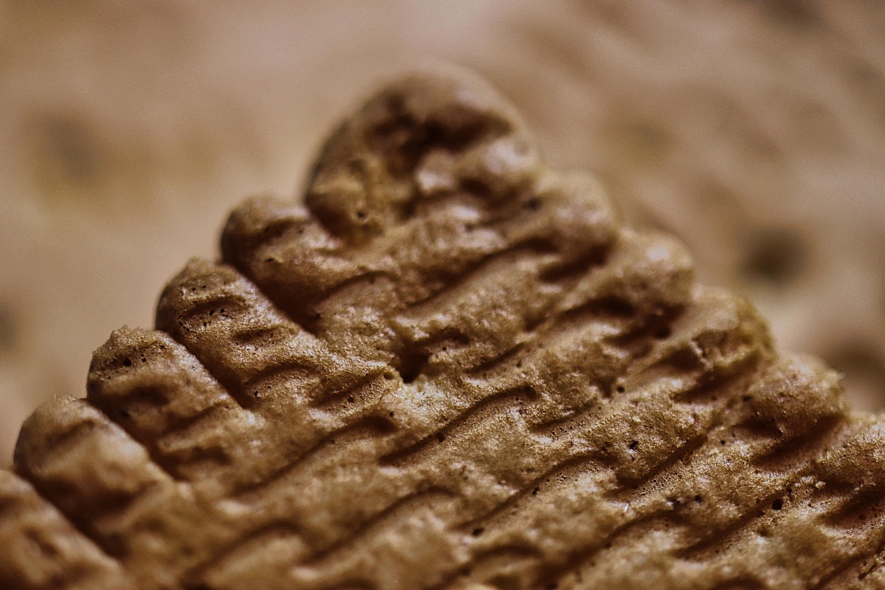 Scritta minuscola su un pacco di biscotti al supermercato, evidenziando ingredienti e allergeni.