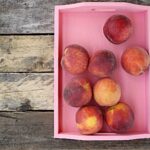 Pesche fresche su un tavolo, simbolo di salute e benessere per la pressione sanguigna.