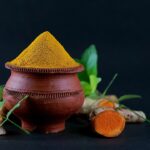 Tisana di curcuma fumante in una tazza, ideale per stimolare il metabolismo.