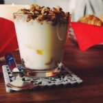 Bicchiere di kefir con frutta fresca, simbolo di una colazione sana per combattere il colesterolo alto.