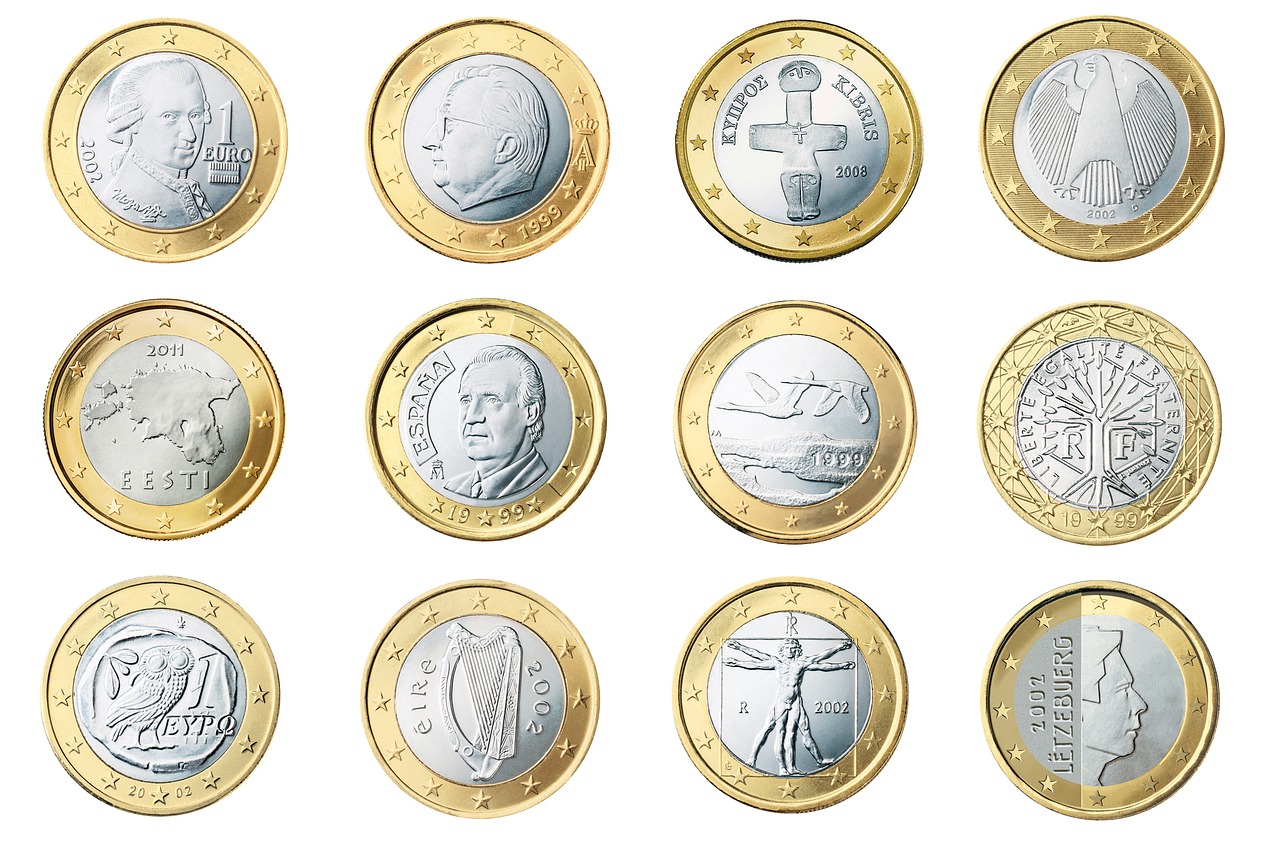 Due monete da 2 euro commemorative rare, esposte su un tavolo, con dettagli visibili delle incisioni.